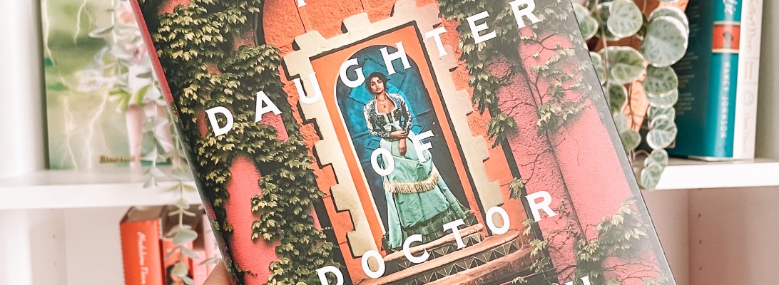 Book cover of The Doctor of Doctor Moreau held up in front of a white bookshelf with garden decorations.